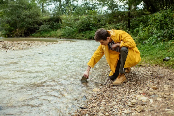 Giovane turista prende acqua pura da un fiume  . — Foto Stock