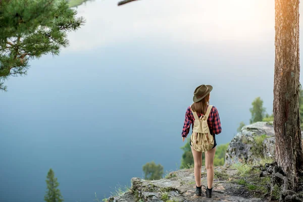 Genç yürüyüşçü kız tepenin zirvesinde dinlenirken mesafeye bakıyor. — Stok fotoğraf