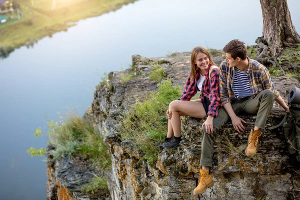 Giovane coppia seduta su una roccia avendo una conversazione — Foto Stock
