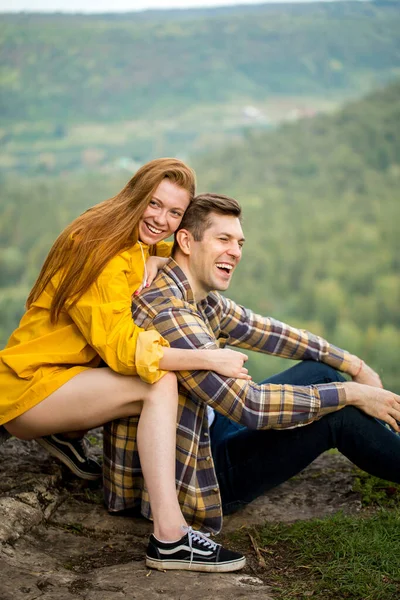 Amante casal positivo sentado no topo da montanha — Fotografia de Stock