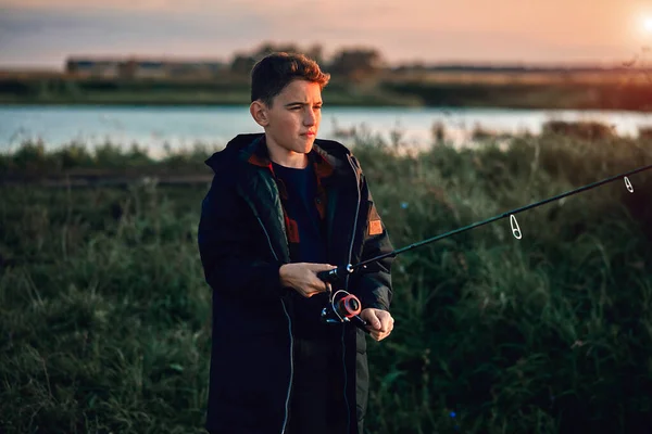 The first joint fishing of adult father and teen son in warm, sunny day. — Stock Image The first joint fishing of adult father and teen son in warm, sunny day. Stock Photo
