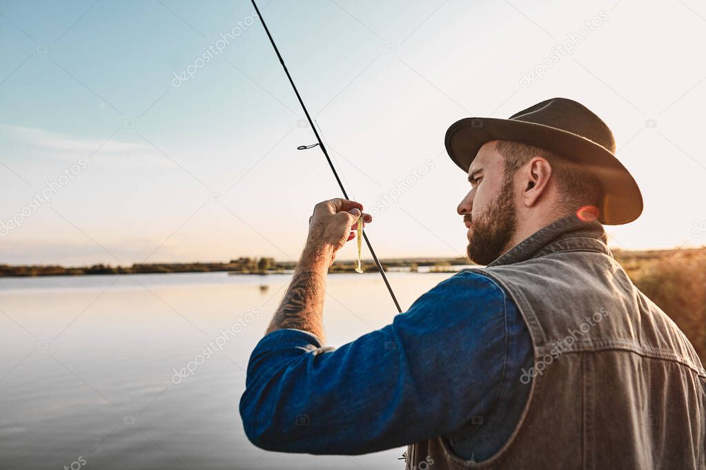 The first joint fishing of adult father and teen son in warm, sunny day.