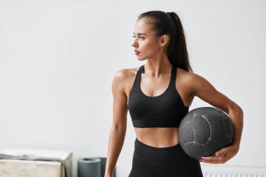 Güzel genç fitness kızı spor topuyla egzersiz yapıyor.
