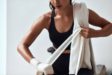 Genç beyaz kadın ellerine elastik bandaj çekiyor.