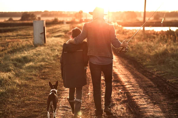 The first joint fishing of adult father and teen son in warm, sunny day. — Stock Photo, Image