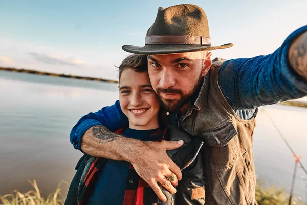 La primera pesca conjunta de padre adulto e hijo adolescente en un día cálido y soleado . —  Fotos de Stock