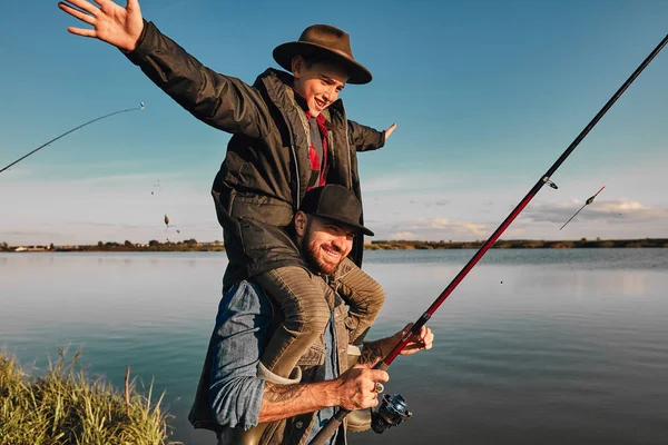 La primera pesca conjunta de padre adulto e hijo adolescente en un día cálido y soleado . — Foto de Stock