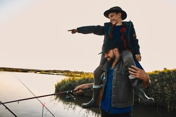 A primeira pesca conjunta de pai adulto e filho adolescente em dia quente e ensolarado . — Fotografia de Stock