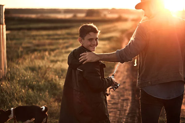 La primera pesca conjunta de padre adulto e hijo adolescente en un día cálido y soleado . — Foto de Stock