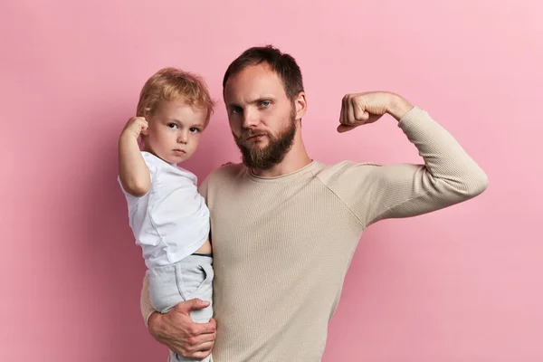 strong man and his son showing their biceps
