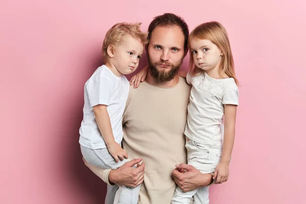 Grappige serieuze vader en kinderen trekken gezichten — Stockfoto
