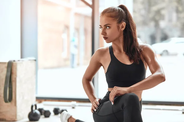 Foto di attraente allungamento femminile sul pavimento in palestra — Foto Stock