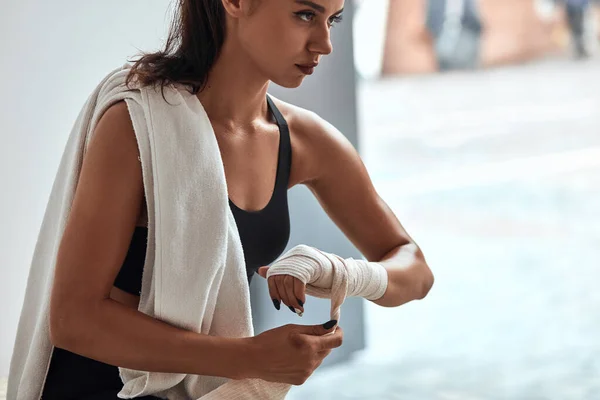 Fuerte chica deportiva envolviendo vendajes en las manos preparándose para el entrenamiento —  Fotos de Stock