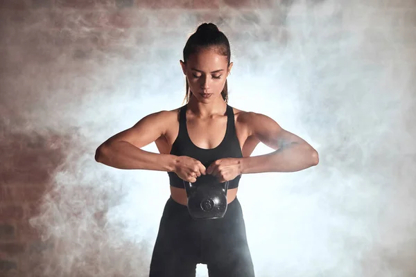 Fitness crossfit žena stojí drží kettlebell — Stock fotografie