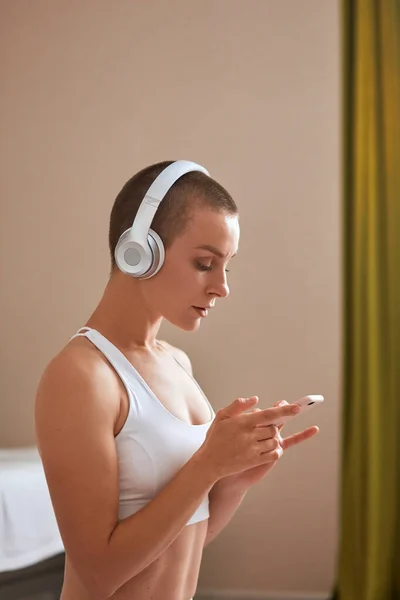 Mulher branca assistindo variações de ioga no smartphone e indo para o exercício em casa fundo com espaço de cópia — Fotografia de Stock