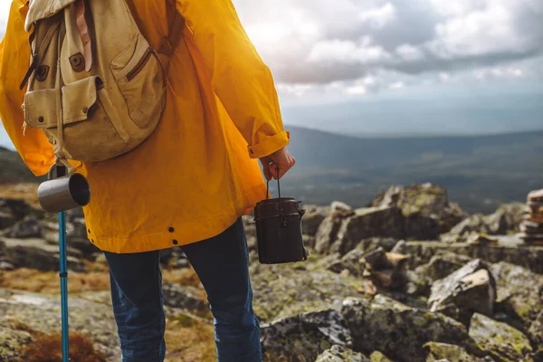 Homem de casaco amarelo em pé no topo da montanha — Fotografia de Stock