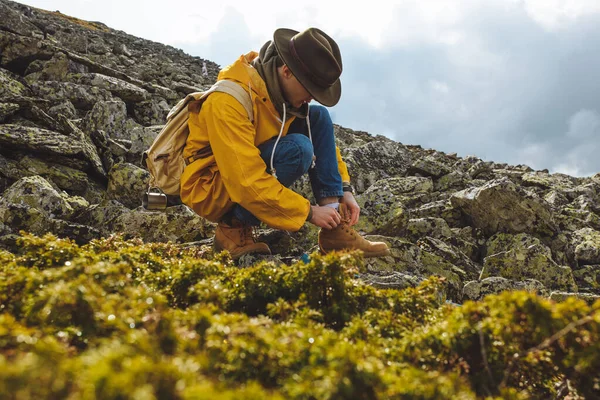 Caminhante amarrando atacadores de botas na montanha — Fotografia de Stock