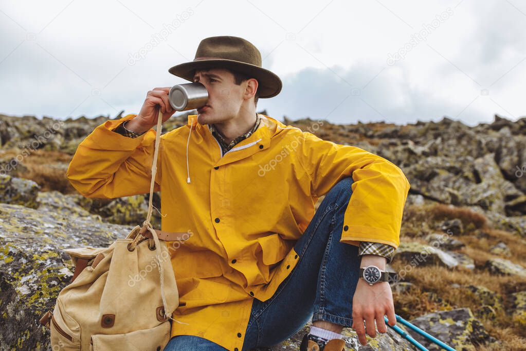 young stylish traveller enjoying drinking hor tea