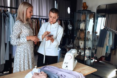 Kadın moda tasarımcısı alıcıyla tartışıyor