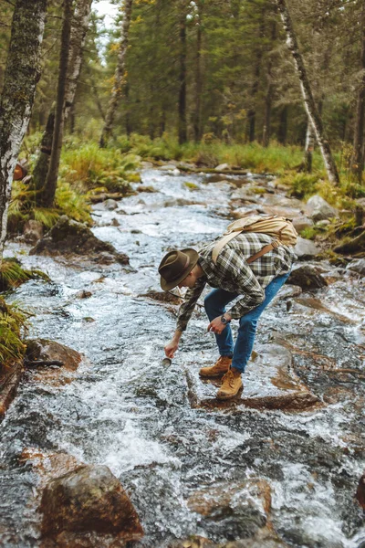 Mladý turista čerpá studenou vodu do svého poháru — Stock fotografie