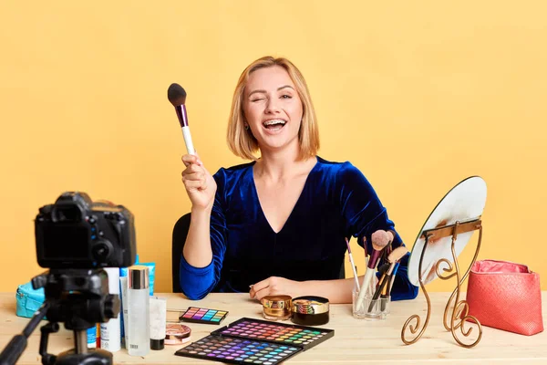 Joyful cosmetics expert blinks with eye, promotes brand-new make up products — Stock Photo, Image