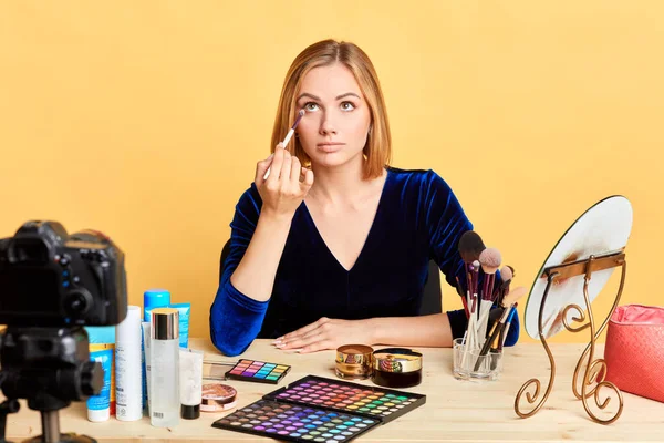 Lovely female beauty blogger applying eyeshadows, presenting new cosmetics line — Stock Photo, Image