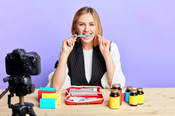 Health and beauty female blogger clenching between her teeth medical syringe — Stock Photo, Image