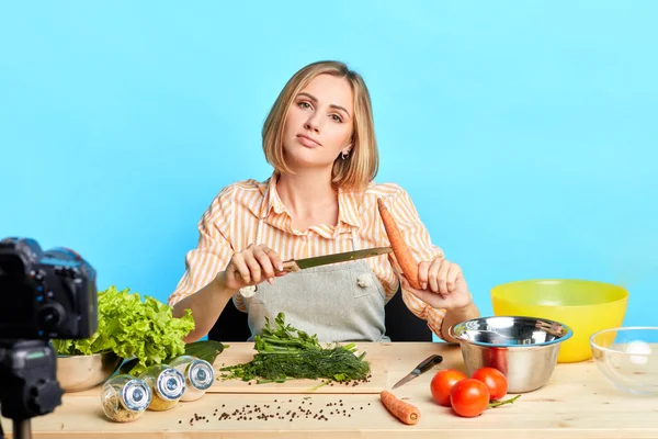 Food blogger dívka drží loupanou mrkev, bude vařit lahodnou vegetariánskou polévku — Stock fotografie