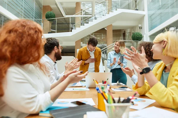 Diseñadores felices sentados a la mesa en una oficina creativa —  Fotos de Stock