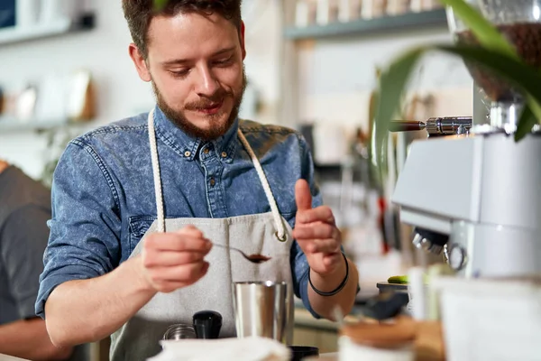 Skillful bartender measures coffee for cup of latte — Stock Photo, Image
