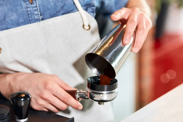 Barista puts ground coffee into tamperr in modern cafe — Stock Photo, Image