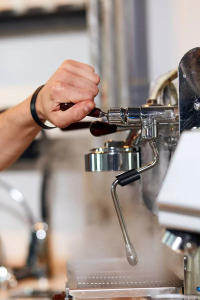 Hand of barista holds handle of grinder — Stock Photo, Image
