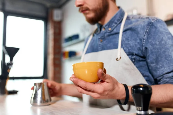 Young barista preparing cappuccino in coffee shop — Stock Photo, Image