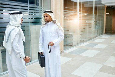 İki ciddi Arap işadamı iş görüşmesi hakkında konuşuyor.