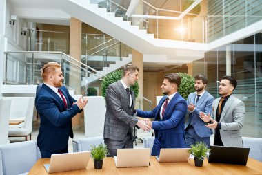 Foreign business people shaking hands, finish up meeting clipart