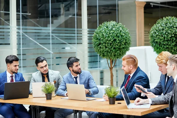 Pessoas de negócios na mesa de negociação no escritório com laptops — Fotografia de Stock