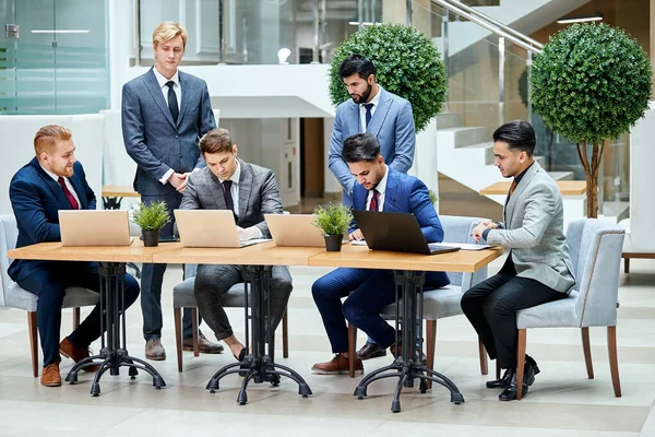 Concepto global de negocios, tecnología y personas. Hombres jóvenes negociadores —  Fotos de Stock