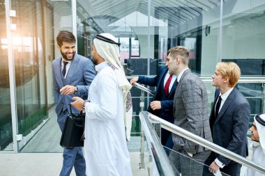 İş adamları merdivenleri çıkarken fikirlerini tartışıyor.