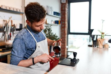 Yakışıklı barmen müşteriye kahve hazırlıyor.