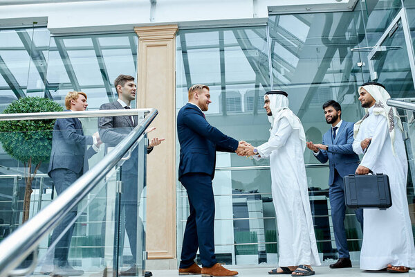 Sheikh and caucasian businessman shaking hands