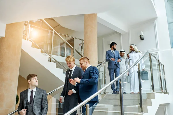 Üzletemberek szmokingban lefelé a lépcsőn. — Stock Fotó
