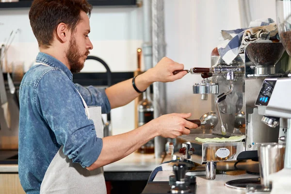 Barista barbudo haciendo espresso aromático fresco —  Fotos de Stock