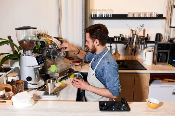 Young barista preparing cappuccino in coffee shop — Stock Photo, Image