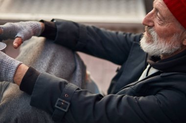 Yakın plan evsiz biri yardım bekliyor. İşsiz dilenciler sokakta yaşar