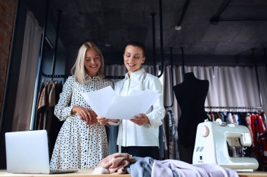 Moda terzisi yeni elbise hakkında müşteriyle iletişim kurar