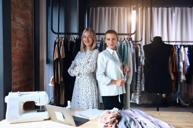 Kadın terzi ve müşteri kameraya bakar