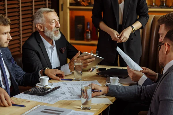 Socios comerciales que discuten documentos e ideas en la reunión — Foto de Stock