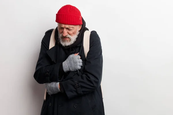 Homeless man bum dressed in black warm old big-sized clothing tries to warm up — Stock Photo, Image