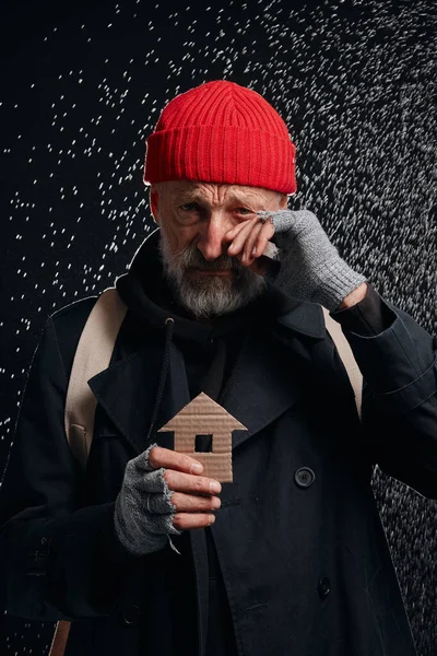 Velho mendigo masculino sonho sobre casa, abrigo de pé sob chuva — Fotografia de Stock