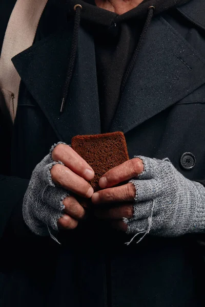 Unrecognizable male hand holding piece of bread — Stock Photo, Image